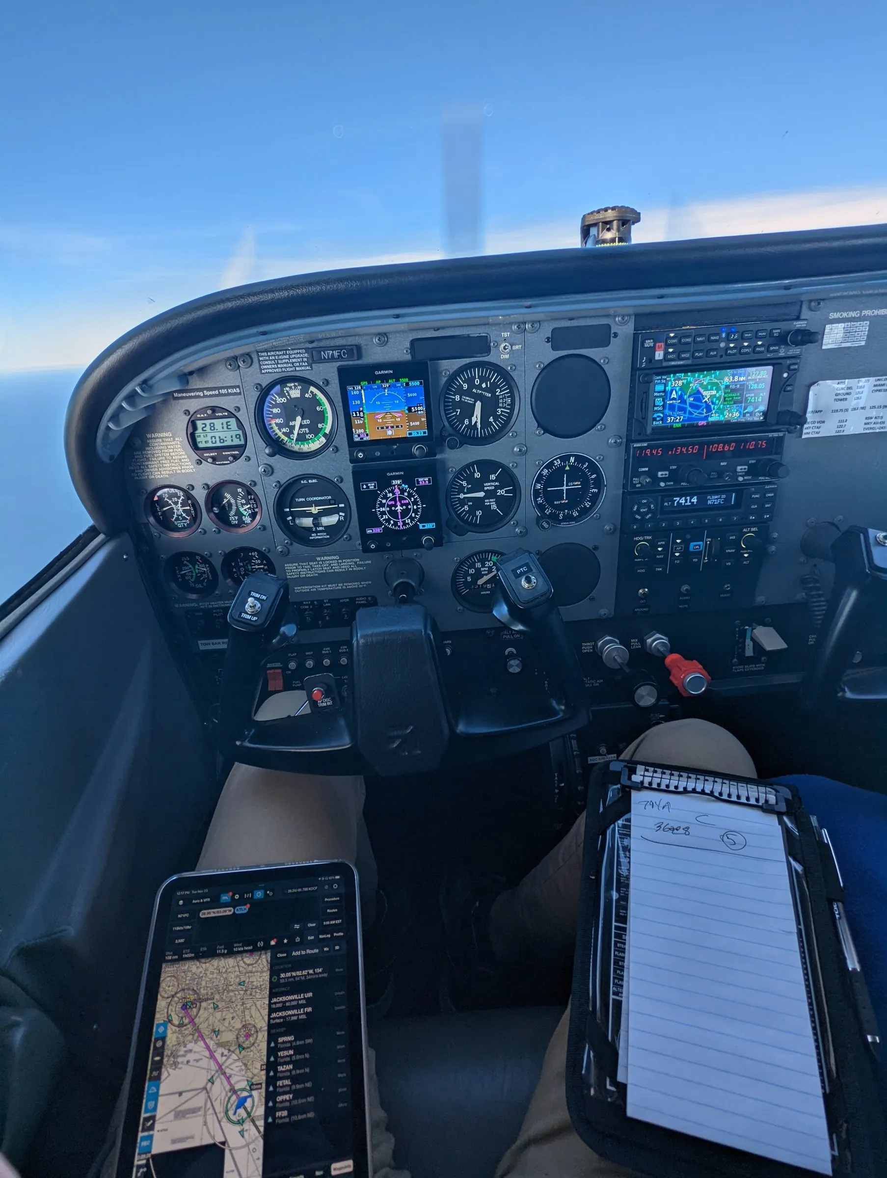 Cessna 172R instrument panel in flight with a flight plan on a kneeboard