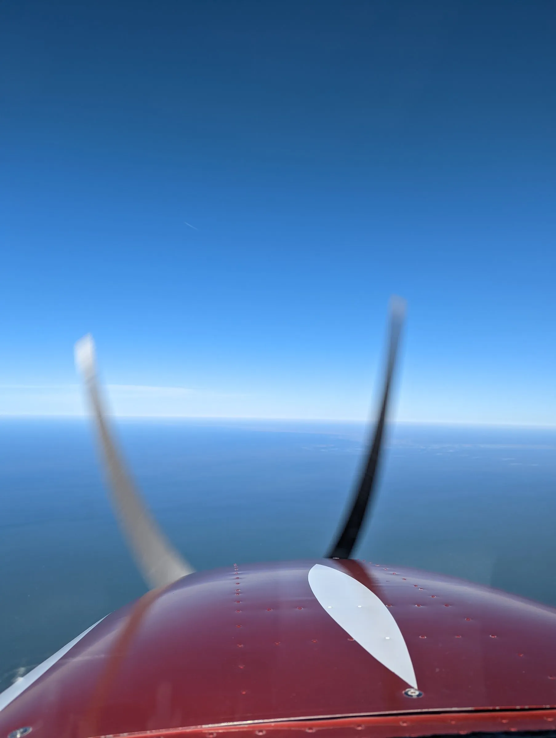 Red cowl + prop arc + Gulf horizon