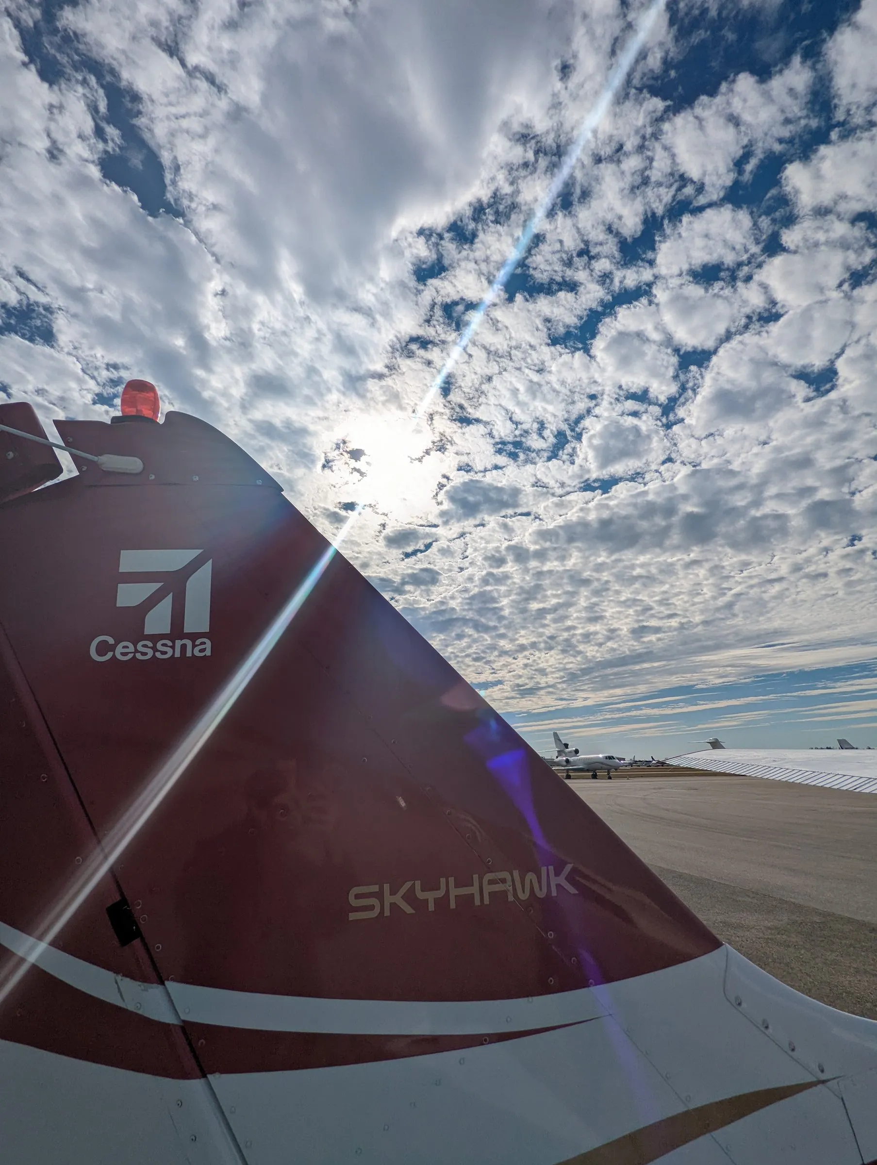 Deep-red tail of Naples Flying Club Cessna 172R Skyhawk N71FC against a mackerel sky